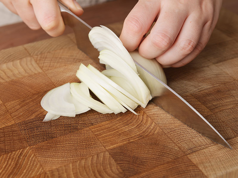 鍋に湯を沸騰させ、豚肉をさっと湯にくぐらせて脂を落とします。玉ねぎは縦半分に切り、繊維にそって薄切りにします。