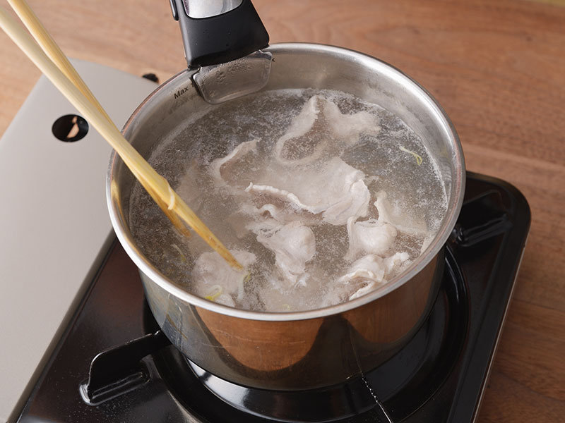 鍋に湯を沸騰させ、もやしをさっとゆでて、ざるにあげます。同じ湯で豚肉をゆでて、ざるにあげます。
