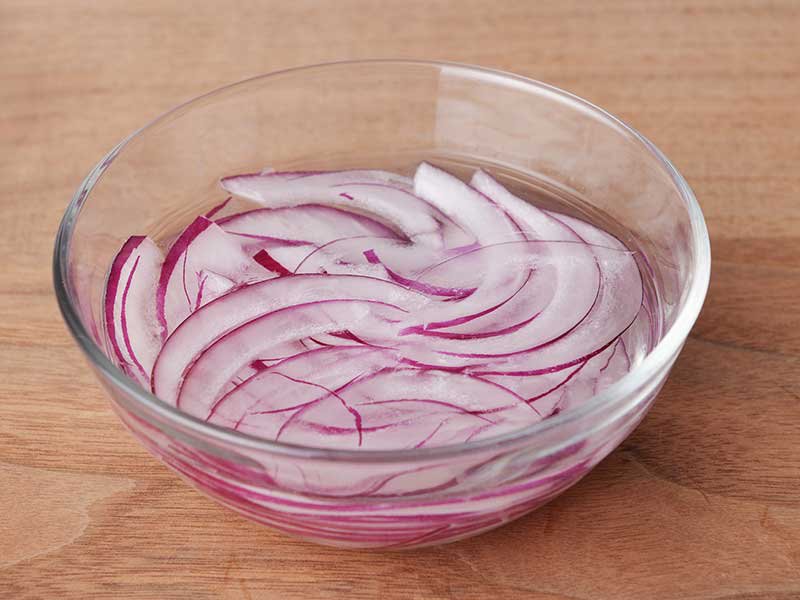 赤玉ねぎは薄切りにし、水にさらして水けを切ります。トマトは半月の薄切り(または薄い輪切り)にします。