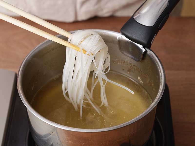 鶏肉を取り出し、ナムプラー、1の麺を加えて中火にし、ひと煮立ちさせます。